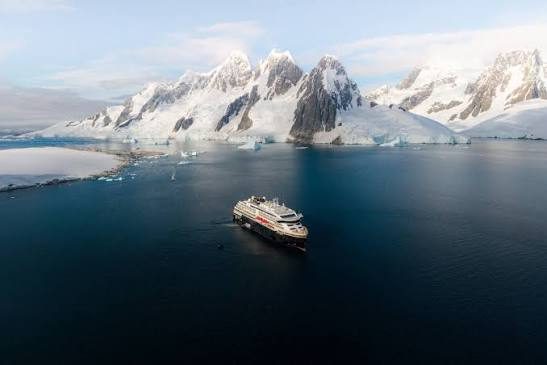 HX expedition ship sailing past icebergs off Greenland’s west coast